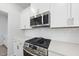 Close-up of the stovetop featuring white cabinets, quartz countertop, and stainless steel appliances at 77 Buckhorn Branch Park # 174, Clayton, NC 27520