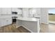 Modern kitchen featuring white cabinets, a large island, stainless steel appliances, and hardwood flooring at 77 Buckhorn Branch Park # 174, Clayton, NC 27520