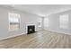 Cozy living room featuring a fireplace, hardwood floors, and natural light streaming through multiple windows at 77 Buckhorn Branch Park # 174, Clayton, NC 27520