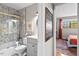 Stylish bathroom with mosaic tile in the shower/tub and gold accents near the adjacent bedroom at 807 W Trinity Ave # 220, Durham, NC 27701