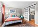 Bright bedroom with colorful accents, including an orange quilt and a teal chair at 807 W Trinity Ave # 220, Durham, NC 27701