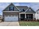 Charming brick home with a two-car garage, covered front porch, and manicured lawn at 1060 Fairhaven Dr # 96, Mebane, NC 27302