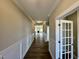 Hallway with hardwood floors and wainscotting leading to a living space with fireplace at 1060 Fairhaven Dr # 96, Mebane, NC 27302