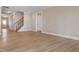 Open-concept living room with hardwood floors, white trim, staircase and access to other rooms at 1060 Fairhaven Dr # 96, Mebane, NC 27302