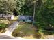 Aerial view of a house with a long driveway, mature trees, and green lawn at 2704 Ross Rd, Durham, NC 27703
