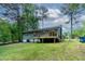 Backyard view showcasing a wood deck, green lawn, and the rear exterior of the house at 2704 Ross Rd, Durham, NC 27703