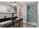 The renovated bathroom features double vanity, glass shower and stylish tile flooring at 2704 Ross Rd, Durham, NC 27703