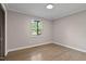 This bedroom features hardwood flooring, a neutral color palette and a window view at 2704 Ross Rd, Durham, NC 27703