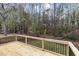 Wooden deck with black railings overlooking a wooded backyard with mature trees at 2704 Ross Rd, Durham, NC 27703