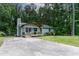 Quaint single-story home with a concrete driveway surrounded by lush greenery at 2704 Ross Rd, Durham, NC 27703