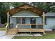 Inviting front porch with new wooden deck, decorative door, and updated lighting fixtures at 2704 Ross Rd, Durham, NC 27703