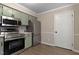 A well-lit kitchen with stainless steel appliances, light green cabinetry, and hardwood flooring at 2704 Ross Rd, Durham, NC 27703