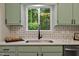 This kitchen showcases a stainless steel sink and a window overlooking a lush forest at 2704 Ross Rd, Durham, NC 27703
