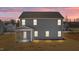 Back of a gray home at dusk, illuminated by exterior lights at 585 Husketh Rd, Youngsville, NC 27596