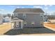 Rear view of a gray two-story home featuring a covered patio and large windows at 585 Husketh Rd, Youngsville, NC 27596