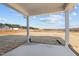 Covered back porch overlooking the expansive backyard and natural landscape at 585 Husketh Rd, Youngsville, NC 27596