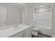 Bathroom with single sink, white countertops, and white cabinets, complemented by wood-look flooring, and shower-tub combo at 585 Husketh Rd, Youngsville, NC 27596