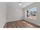 Bright room featuring a large window, and wood flooring at 585 Husketh Rd, Youngsville, NC 27596