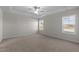 Large bedroom featuring plush carpeting, a ceiling fan, and ample natural light from two windows at 585 Husketh Rd, Youngsville, NC 27596