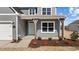 Inviting front porch with decorative wood pillars, fresh landscaping, and a stylish teal door at 585 Husketh Rd, Youngsville, NC 27596