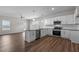 Bright, open kitchen featuring stainless steel appliances, granite countertops, and hardwood flooring at 585 Husketh Rd, Youngsville, NC 27596