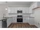 Modern kitchen featuring white cabinets, stainless steel appliances, and granite countertops at 585 Husketh Rd, Youngsville, NC 27596