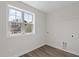 Bright laundry room with wood-look floors and a window for natural light at 585 Husketh Rd, Youngsville, NC 27596