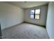 Neutral bedroom with carpeting and a single window, offering a view of the neighborhood at 6040 Scalybark Road, Durham, NC 27712