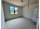 Cozy bedroom with neutral carpeting, a single window, and a simple ceiling fan at 6040 Scalybark Road, Durham, NC 27712