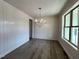 Formal dining room with wainscoting, dark wood floors, and large picture window at 6040 Scalybark Road, Durham, NC 27712