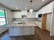 Modern kitchen with white cabinets, granite countertops, stainless steel appliances, and center island at 6040 Scalybark Road, Durham, NC 27712