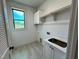 Functional laundry room features a utility sink, white cabinets, and convenient hanging rod at 6040 Scalybark Road, Durham, NC 27712