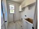 Well-lit laundry room includes a window, cabinetry and shelving at 6040 Scalybark Road, Durham, NC 27712