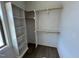 Bright walk-in closet featuring custom white shelving and wood closet rods for ample storage at 6040 Scalybark Road, Durham, NC 27712