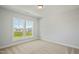 Bright bedroom featuring a large window with neighborhood views and neutral carpeting at 441 Edison Rail Ln, Knightdale, NC 27545