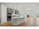 Open concept kitchen with a large island, stainless steel appliances, and seamless flow into the living area at 441 Edison Rail Ln, Knightdale, NC 27545