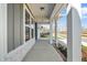 Long covered front porch features stone accents, a concrete floor, and a view of the neighborhood at 441 Edison Rail Ln, Knightdale, NC 27545