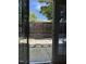 A view of a backyard with stone pavers, a wooden fence, and a gate as seen through a glass door at 4429 Log Cabin Dr, Raleigh, NC 27616