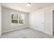 Cozy bedroom with plush carpeting and a large window overlooking a wooded area at 88 Bering Cir, Angier, NC 27501