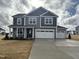 A two-story house features a driveway, three-car garage, and gray siding at 88 Bering Cir, Angier, NC 27501
