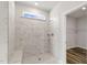 Elegant shower with marble-look tile, built-in bench, recessed shelves, and a clerestory window at 88 Bering Cir, Angier, NC 27501