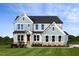 Two-story home with gray siding, stone accents, and a landscaped lawn at 149 Brandy Ml, Pittsboro, NC 27312