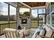 Relaxing screened porch with stone fireplace, comfortable seating, and a TV at 149 Brandy Ml, Pittsboro, NC 27312