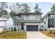 Contemporary two-story home with a gray exterior, black garage door, and manicured lawn at 2417 Mayview Rd, Raleigh, NC 27607