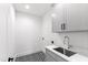 Laundry room with utility sink and gray cabinets at 2417 Mayview Rd, Raleigh, NC 27607