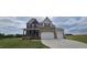 Beautiful two-story home featuring stone accents, a two-car garage, and a well-manicured front lawn at 271 White Azalea Way, Homesite 30, Benson, NC 27504