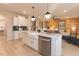 A kitchen boasts a white center island, pendant lighting, and stainless steel appliances, next to a living space at 271 White Azalea Way, Homesite 30, Benson, NC 27504