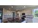 Open kitchen with white cabinetry, granite countertops, a central island, and stainless steel appliances at 271 White Azalea Way, Homesite 30, Benson, NC 27504
