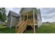 Exterior view of a raised porch and the back of a new home with a spacious yard at 294 White Azalea Way, Homesite 74, Benson, NC 27504