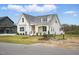 Attractive white home with a covered porch, manicured lawn, street view and a pond at 3804 Cobbler View Way, Fuquay Varina, NC 27526